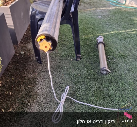 מנוע לתריסים חשמליים מונח על כיסא פלסטיק